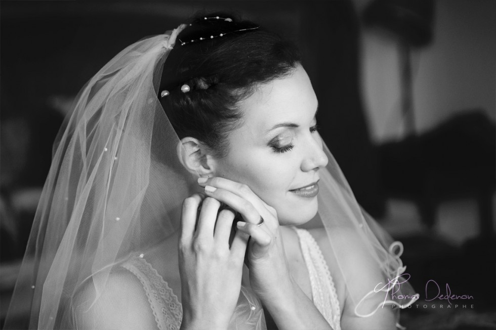 Préparatifs de la mariée qui met ses boucles d'oreilles