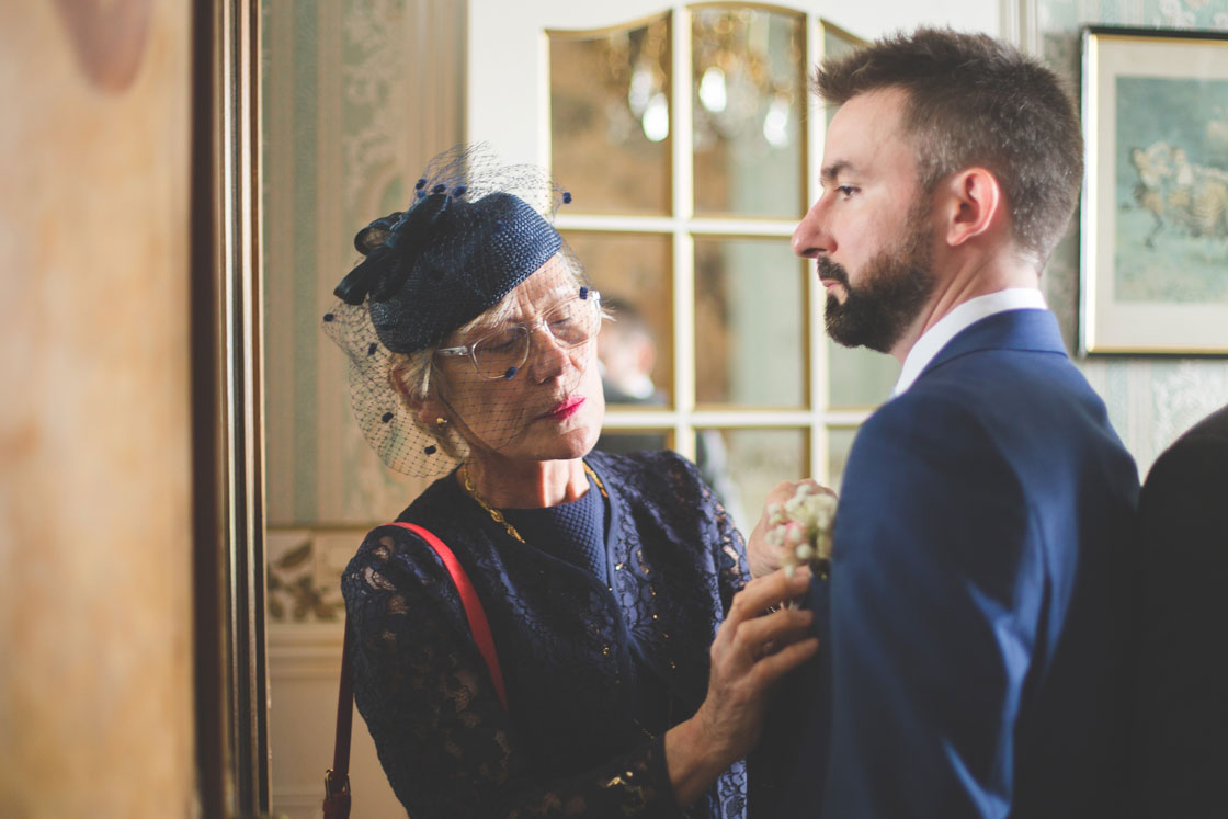 la mère du mariée ajuste la boutonnière