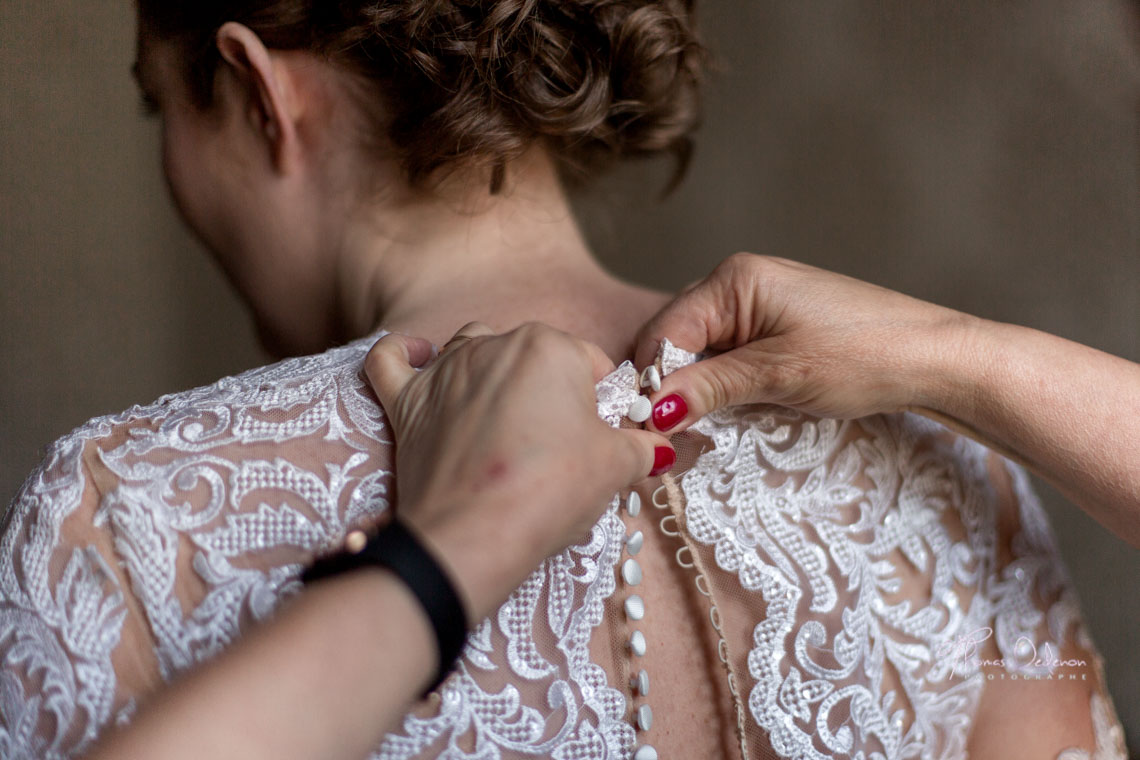 Une mère ferme la robe de mariée de sa fille