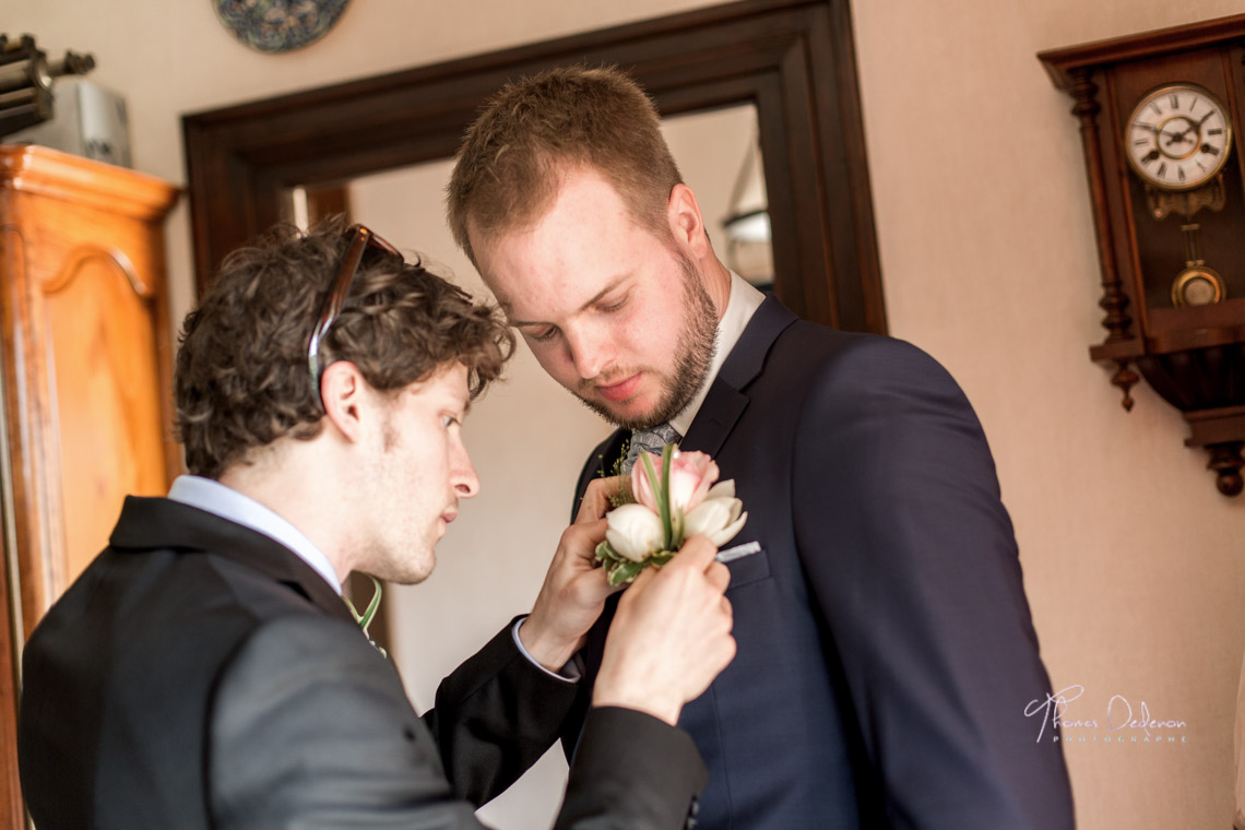 Le témoin met la boutonnière au marié